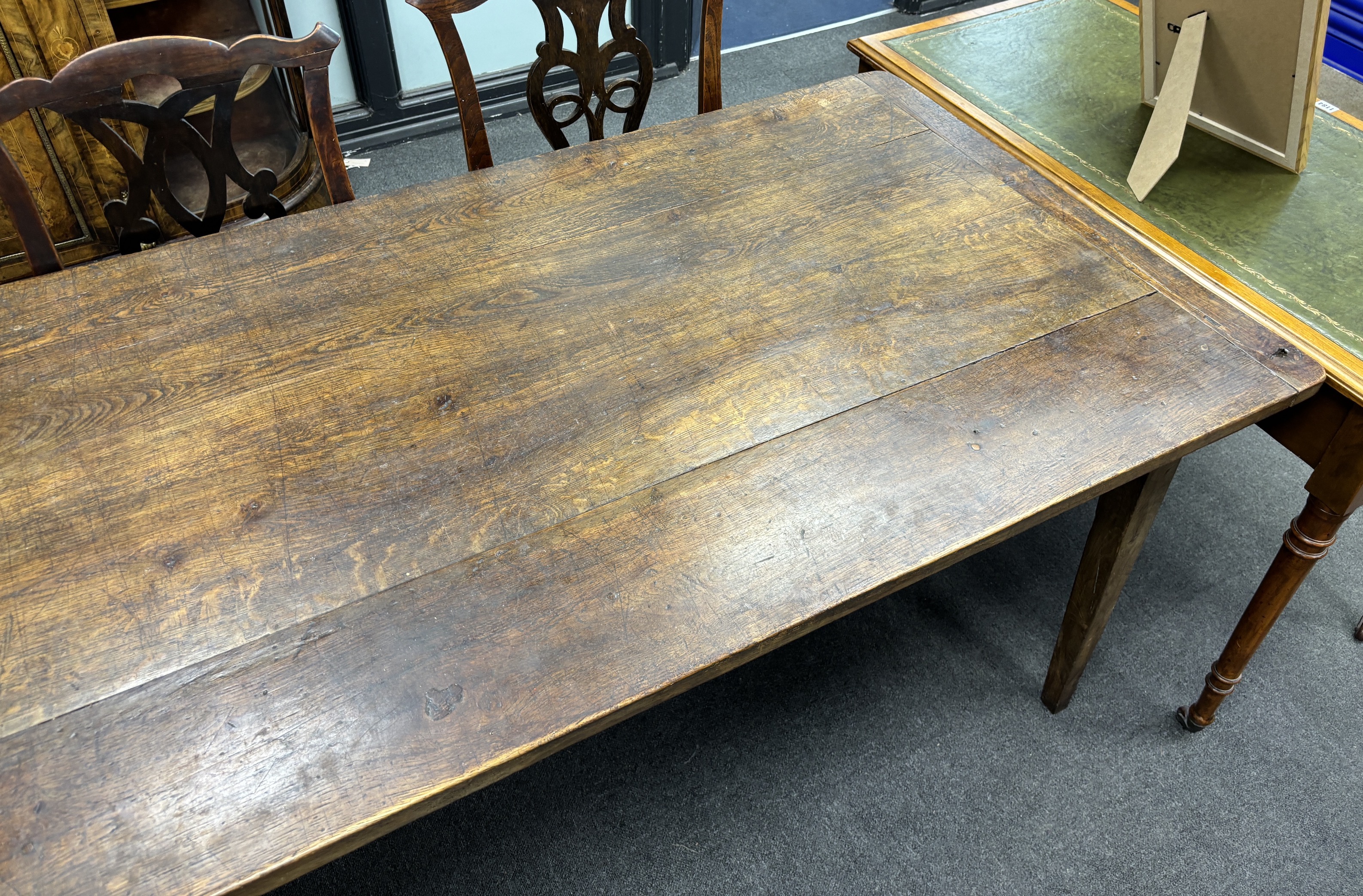 A 19th century rectangular Provincial oak kitchen table with cleated plank top, fitted two drawers on square tapered legs, width 220cm, depth 84cm, height 74cm